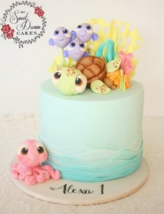 there is a blue cake with sea animals on it and an octopus under the cake