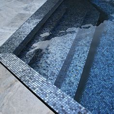 an empty swimming pool with blue tiles on the floor