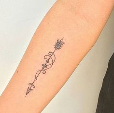 a woman's arm with an arrow tattoo on it