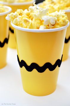 small yellow cups filled with popcorn sitting on top of a table