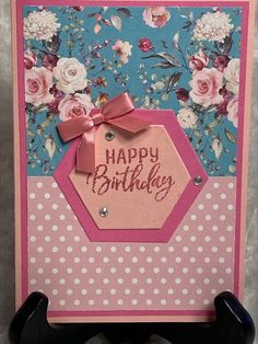 a happy birthday card with flowers and polka dots on the bottom, pink ribbon tied around it