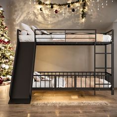 there is a bunk bed with a slide on the bottom and a christmas tree in the background