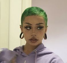 a woman with green hair and piercings on her face