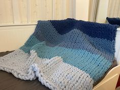 a crocheted blanket sitting on top of a bed