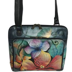 a handbag with flowers painted on the front and side panels, black leather handles