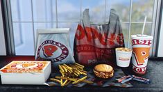 an image of fast food and drinks on the counter in front of a windowsill