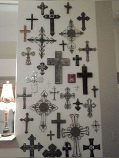 a wall with many crosses on it and a lamp in the corner next to it