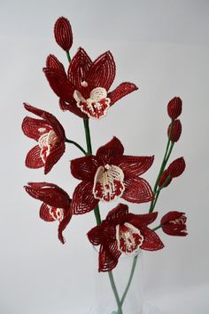 a glass vase filled with red flowers on top of a table