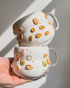 two mugs that have been decorated with cookies on them