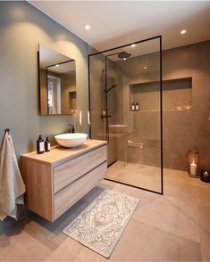 a bathroom with a sink, mirror and shower stall in it's own area