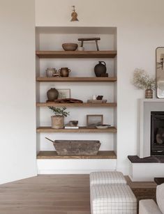 a living room filled with furniture and a fire place next to a wall mounted fireplace