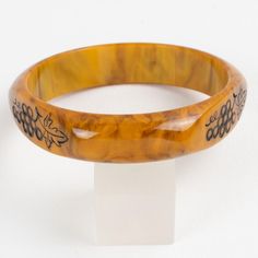 This is part of Chairish’s Costume Jewelry assortment.  Stunning Mississippi swamp marble Bakelite carved bracelet bangle. Domed shape with three flat areas and carved designs. The design features bunches of grapes with black contrast. Intense gold butterscotch marble tone with brown cloudy swirling also called Mississippi swamp color.  Measurements: Inside across is 2.63 in diameter (6.7 cm) - outside across is 3.19 in diameter (8.1 cm) - width is 0.63 in wide (1.6 cm) - Inner circumference is Elegant Tortoiseshell Bangle Jewelry, Elegant Bakelite Bracelet Jewelry, Elegant Bakelite Bracelet, Handmade Bakelite Bangle Bracelet, Elegant Bakelite Bangle As Gift, Elegant Bakelite Bangle As A Gift, Elegant Adjustable Tortoiseshell Bracelets, Carved Bangle Bracelets, Luxury Carved Bangle Bracelet