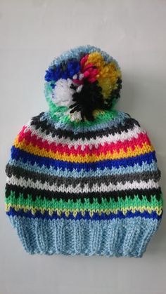 a multicolored knitted hat with pom - pom