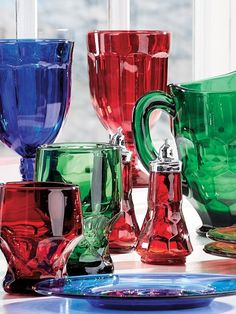 many different colored glass cups on a table