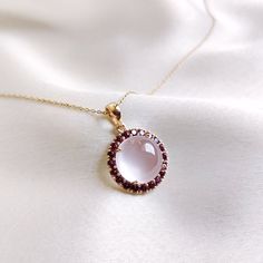 This stunning pendant is set in 14k Solid Yellow Gold with Natural Rose Quartz & Rhodolite Garnet with utmost precision. It is a unique gemstone Pendant for nearly every occasion and is completely hassle-free jewelry. ITEM DETAILS: * Gem: Rose Quartz * Gem Size: 12X12mm * Gem Shape: Round Cab * Gem Weight: 7.24 carats * Gem: Rhodolite Garnet * Gem Size: 2mm * Gem Shape: Round Cut * Gem Weight: 1.0 carats * Total Gem Weight: 8.24carats * Gold Purity: 14KT * Gold Weight: 1.68 gram * Total Weight o Rose Quartz Gold Ring, Elegant Round Rose Cut Diamonds, Elegant Rose Cut Diamonds Gemstones For Gift, Elegant Rose Cut Diamonds For Gifts, Rose Gold Gemstones For Gifts, Fine Jewelry, Rose Gold Fine Jewelry Gemstones As Gifts, Handmade Jewelry Box, Rose Quartz Jewelry, Rose Gold Quartz