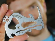 a man holding a multi - tool in his right hand and looking at the camera