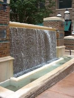 a water fountain in front of a brick building