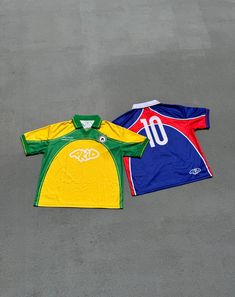 two soccer jerseys laying on the ground next to each other, one is green and yellow