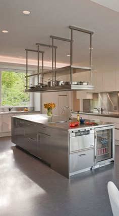 a large kitchen with stainless steel appliances and cabinets in the center, along with an island