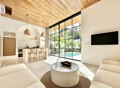 a living room filled with furniture and a flat screen tv on top of a wooden ceiling