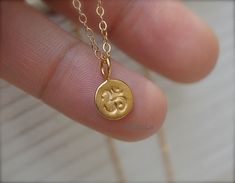 A simple tiny gold vermeil Om necklace hang on a top quality 18 Kt gold filled delicate chain - the chain is shimmering, delicate and sturdy.  Ohm - considered the most sacred mantra. It appears at the beginning and end of most Sanskrit recitations, prayers, and texts. Ohm is the universe - represent all of the consciousness - the past, the present, and the future, all that was, all that is, all that will be is om.  MATERIAL DETAILS   Charm: 24 Kt Gold vermeil tiny ohm charm 8 mm or natural soli Handmade Dainty Charm Necklace, Ohm Necklace, Om Necklace, Spiritual Necklace, Yoga Necklace, 24kt Gold, Gold Dipped, Sanskrit, Spiritual Jewelry