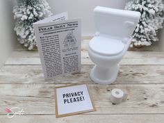 a white toilet sitting on top of a wooden floor next to a piece of paper