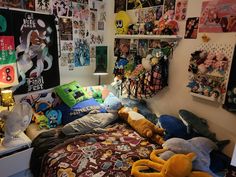 a bed room with a neatly made bed and lots of stuffed animals on the wall