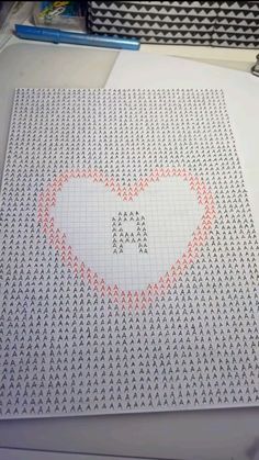 a piece of paper with a heart drawn on it next to some pens and pencils