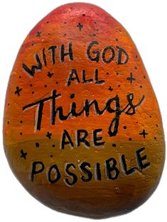 an orange painted rock with the words, with god all things are possible