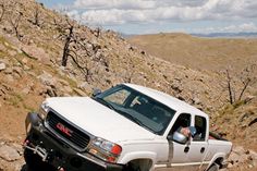 a white truck driving down a rocky hill