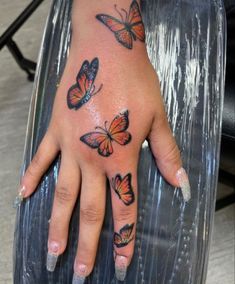 a woman's hand with butterflies on it