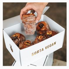 a person holding a pastry in a box