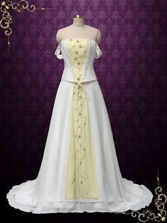 a white and yellow wedding gown on display in front of a purple wall with gold accents