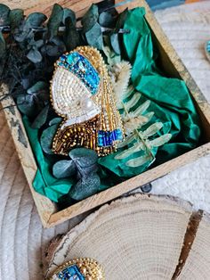 two brooches are sitting in a wooden box