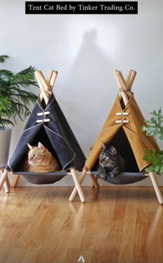 two teepee tents with cats in them sitting on the floor next to each other