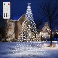 a lighted christmas tree in front of a house