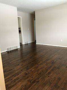 an empty living room with hard wood floors