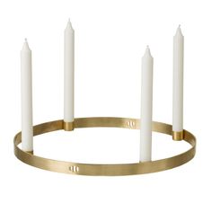 a brass candle holder with five white candles in the center and two gold rings around it