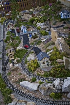 a model train track with houses and trees