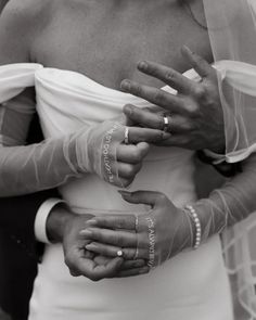 a woman in a wedding dress with her hands wrapped around her waist and wearing gloves