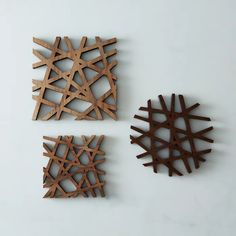 three pieces of wood are arranged on a white surface