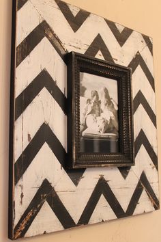 a black and white chevroned frame with a picture hanging on it's wall