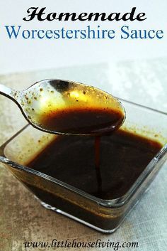 a spoon filled with sauce on top of a table