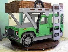 a green and gray toy truck with boxes on top