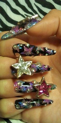 someone is holding five different colored stars on their fingers, all in the same pattern