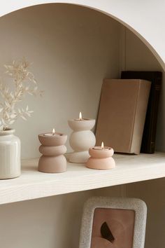 a shelf with candles and vases on it