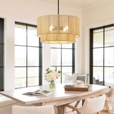 a dining room table with chairs and a chandelier hanging from it's ceiling