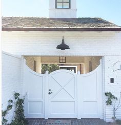 a white brick house with an open gate