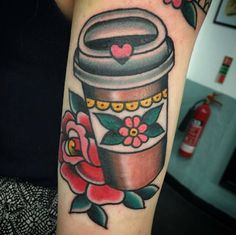 a woman's arm with a flower pot tattoo on it and flowers in the background