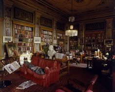 a living room filled with furniture and bookshelves covered in lots of bookcases